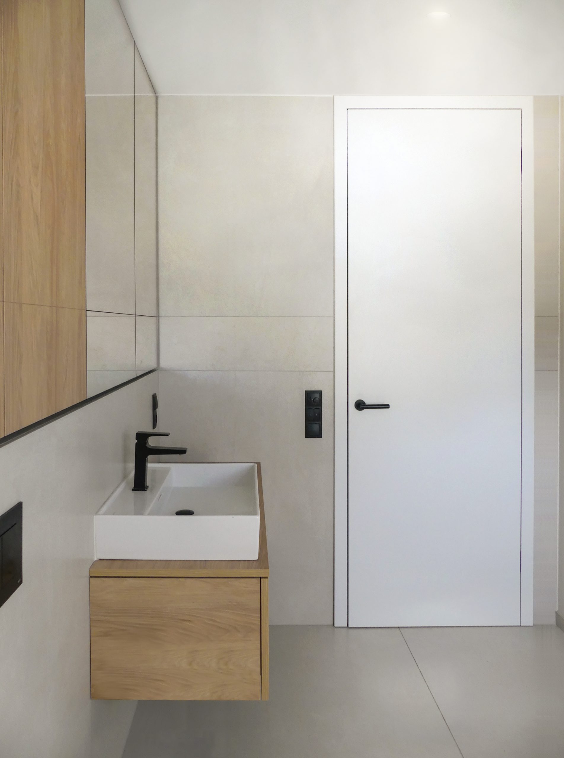 Maßgeschneiderte Innenarchitektur mit Atra Türen von Griffwerk und Laufen Waschtischen mit Hans Grohe Armaturen. Eleganter Spiegelschrank mit viel Stauraum und stilvollem Design für Ihr Badezimmer.