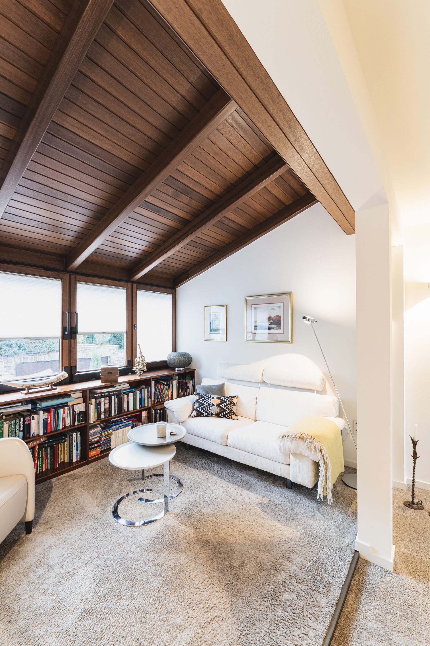 Leselounge mit Holzdecke und viel natürlichem Licht, gestaltet mit hochwertigen Elementen der Bielefelder Werkstätte für ein warmes, zeitloses Interior.