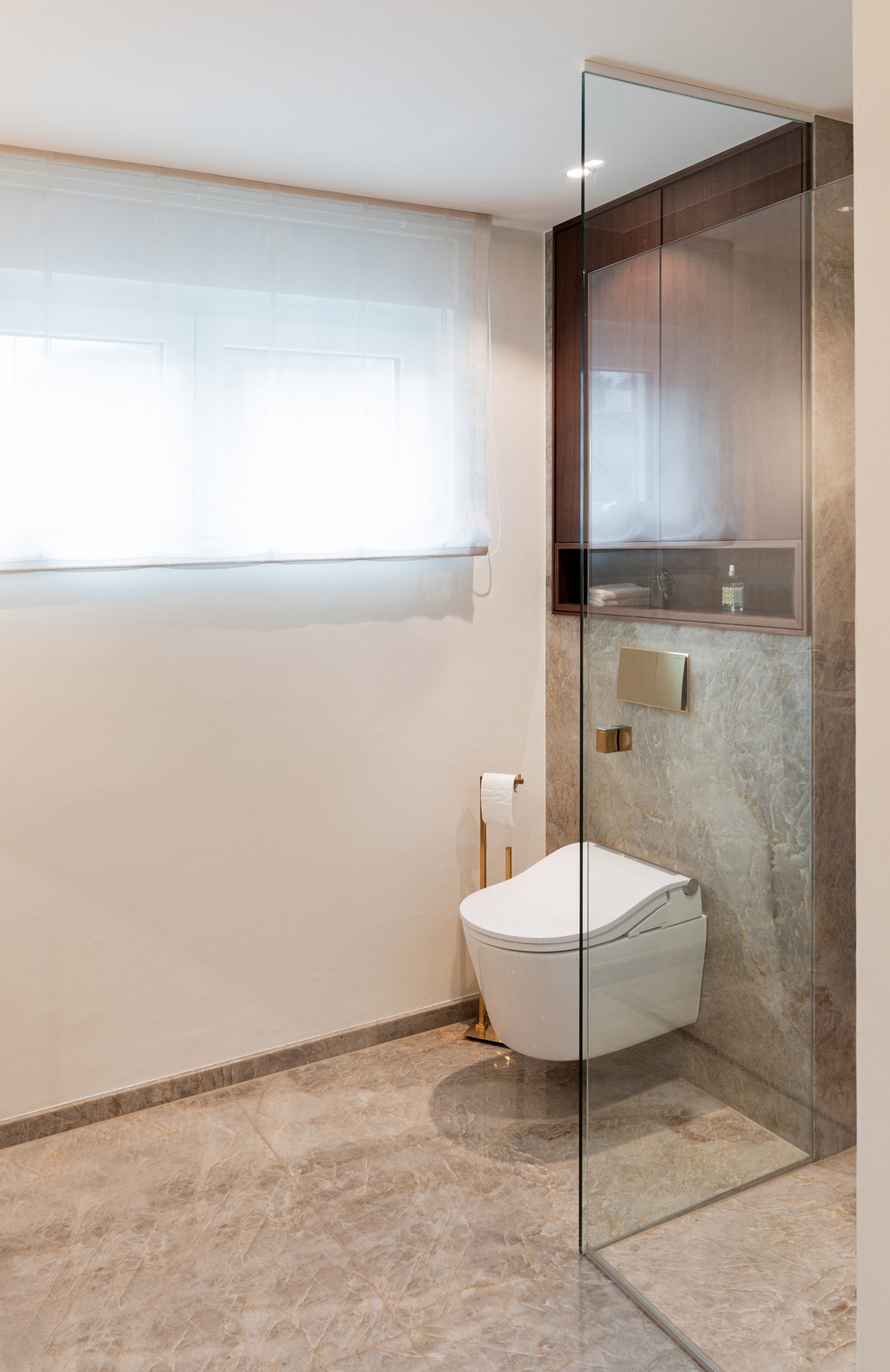 Edler Naturstein mit Tiefe und transparenter Struktur bildet die Grundlage des Designs. Präzise gefertigte Metallarmaturen in hochwertiger Premium-Finish-Ausführung setzen moderne Akzente. Massives Holz und großzügige Designerleuchten ergänzen das Interieur und schaffen eine ruhige, hochwertige Atmosphäre mit klaren Linien und zeitloser Eleganz.