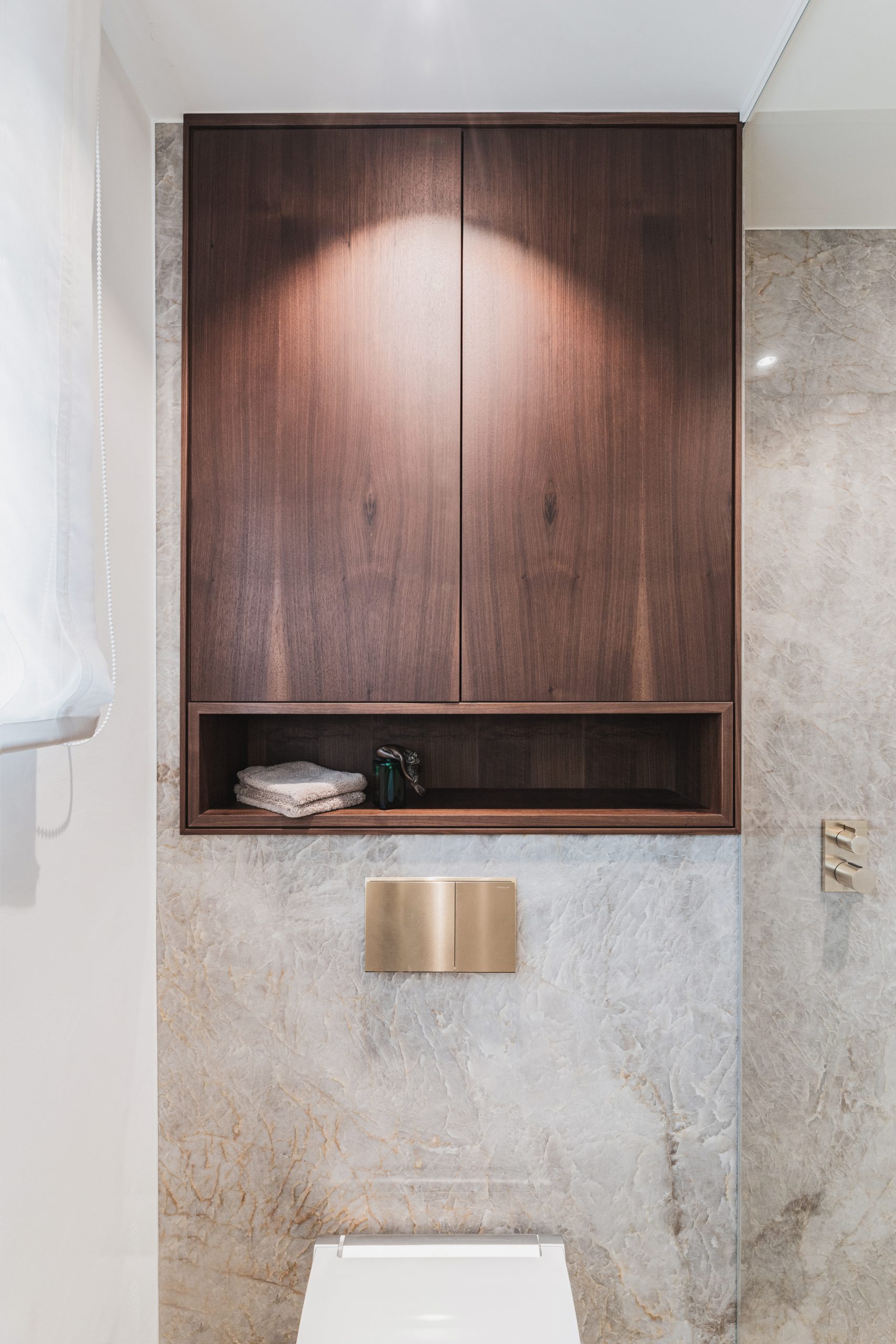 Edler Naturstein mit Tiefe und transparenter Struktur bildet die Grundlage des Designs. Präzise gefertigte Metallarmaturen in hochwertiger Premium-Finish-Ausführung setzen moderne Akzente. Massives Holz und großzügige Designerleuchten ergänzen das Interieur und schaffen eine ruhige, hochwertige Atmosphäre mit klaren Linien und zeitloser Eleganz.