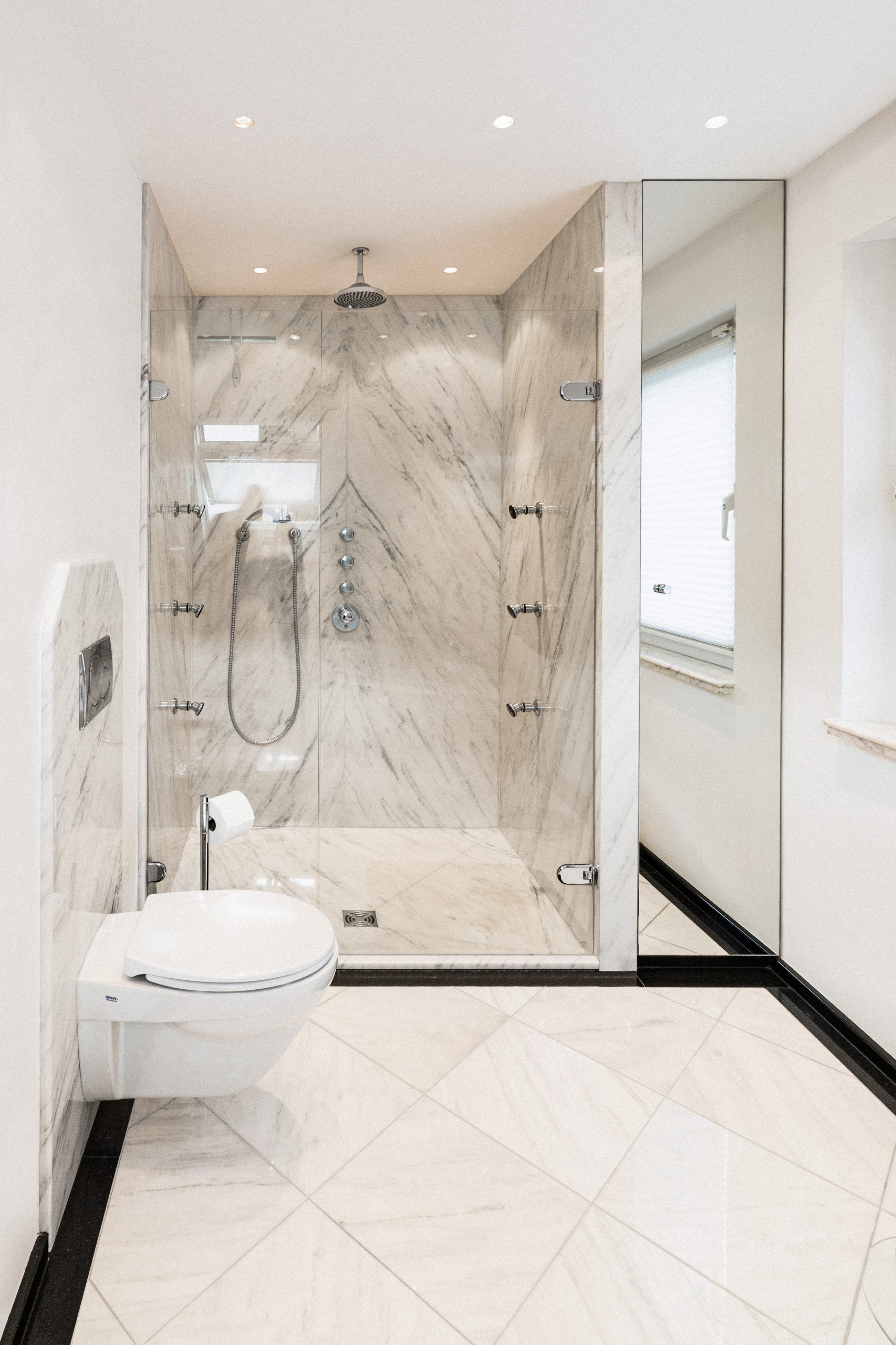 Modernes Masterbad mit neoklassischem Look, funktional geplant und mit optimaler Raumnutzung. Die schwarz-weiße Farbpalette sorgt für zeitlose Eleganz und ein stimmiges, hochwertiges Gesamtbild.